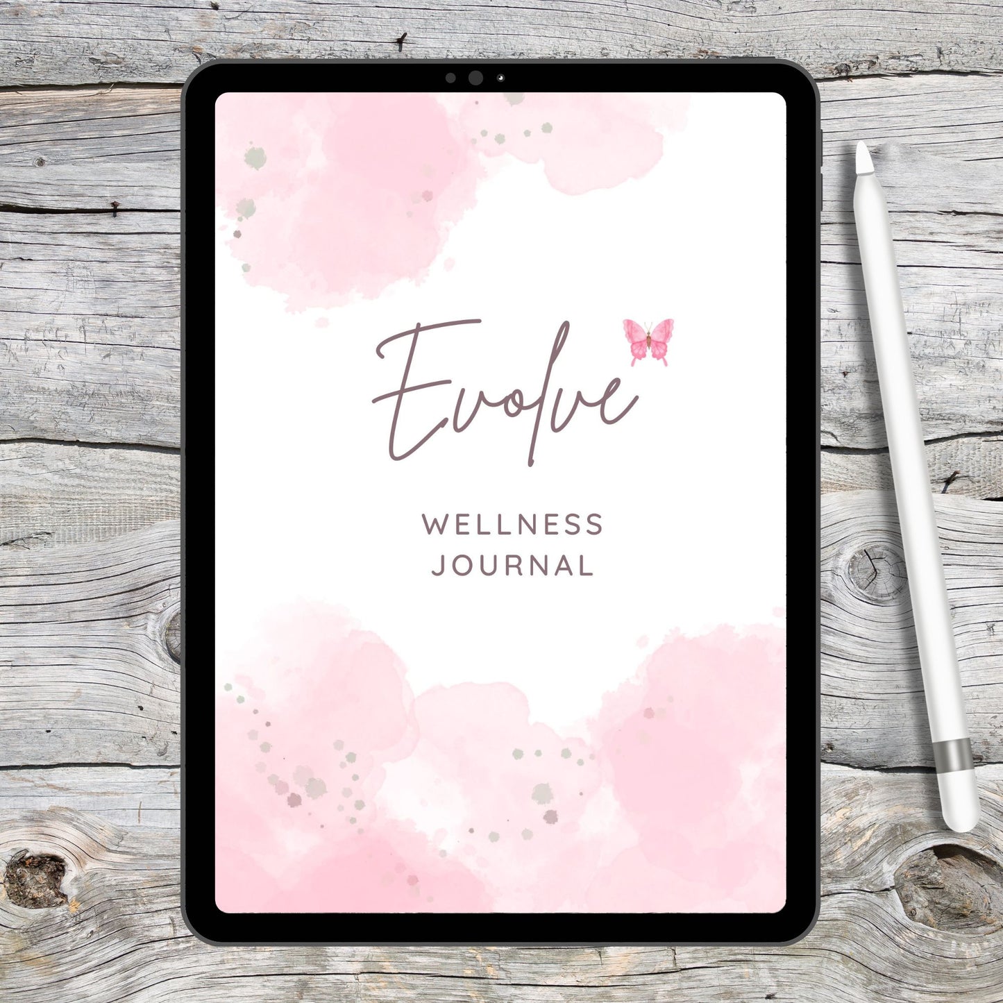 black tablet on grey and white wooden desk next to a white stylus.  Tablet displays pink and white digital wellness journal cover.