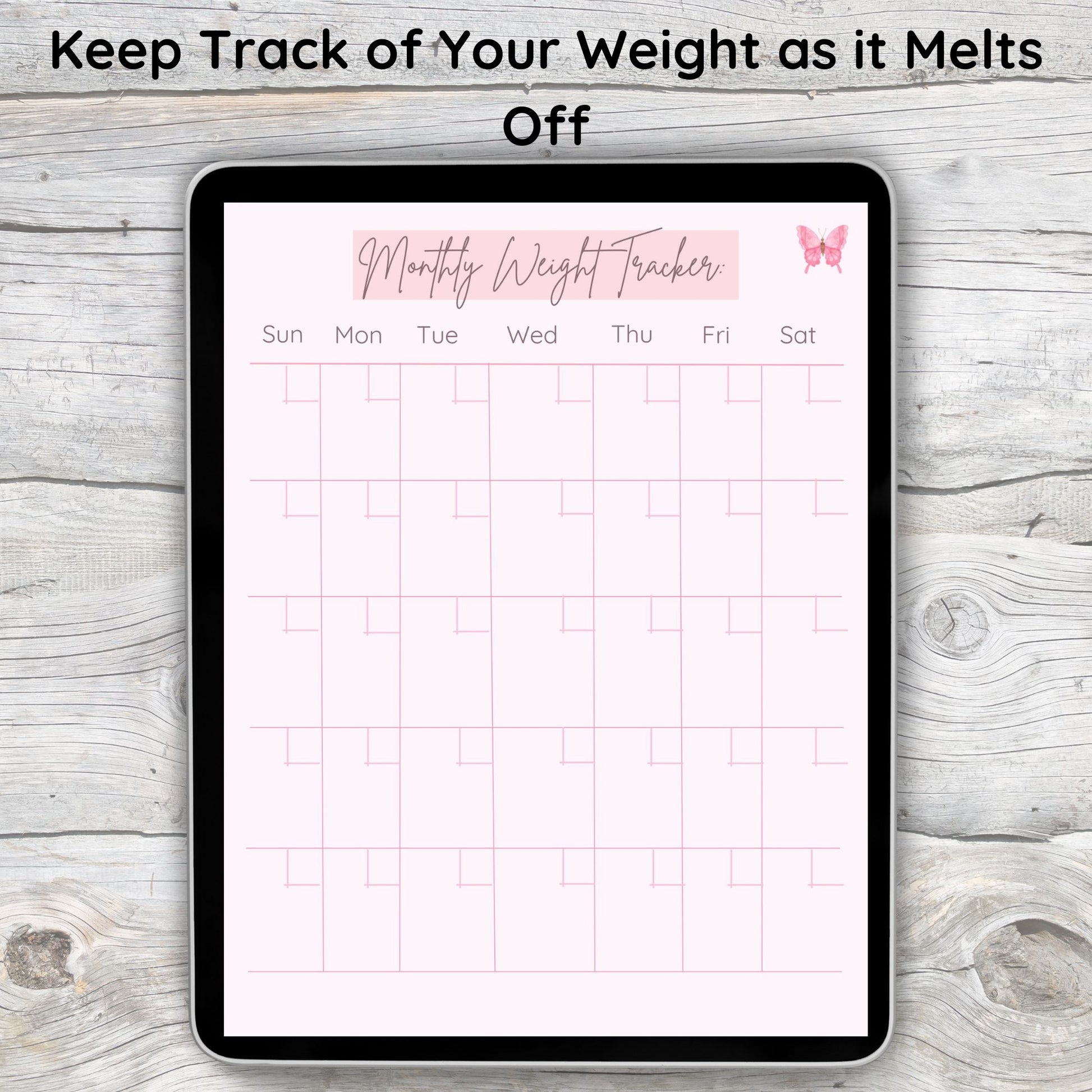 Black tablet laying on grey and white wooden desk.  Tablet displays pink monthly weight tracker page from digital wellness journal.