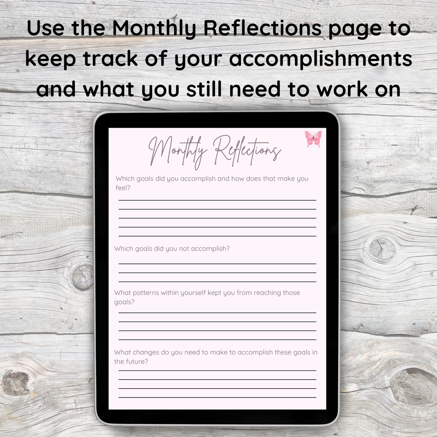 Black tablet laying on grey and white wooden desk.  Tablet displays pink monthly reflections page from digital wellness journal.